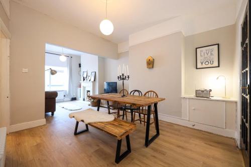 a living room with a wooden table and chairs at GuestReady - Walton's Delight in Liverpool