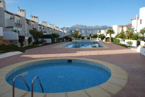 - une piscine au milieu d'une cour avec des bâtiments dans l'établissement Albiretes, à Albir