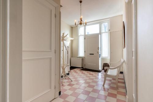 a hallway with a table and a chair and a door at NEW Hello Zeeland - Vakantiehuis Markt 10 in Domburg