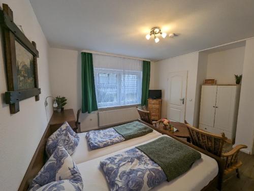 a bedroom with two beds and a table and a window at Haus Am Waldesrand in Herzberg am Harz