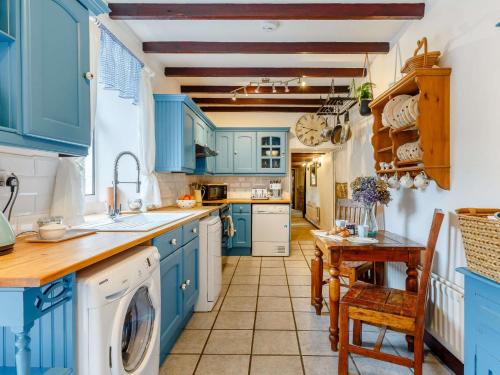 a blue kitchen with a sink and a dishwasher at 3 Bed in Newquay 82369 in Mitchell