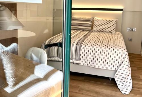 a bedroom with a bed and a glass wall at RIACENTRUM - Smart Residence in Aveiro