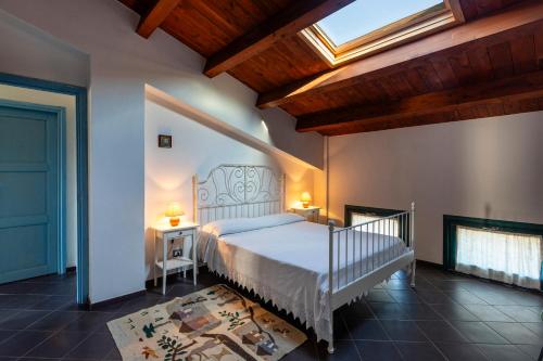 a bedroom with a white bed and a skylight at Case Malavilla in Santa Croce Camerina