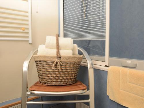 a basket of towels sitting on a chair in a bathroom at 2 Bed in Bewdley CC090 in Bayton