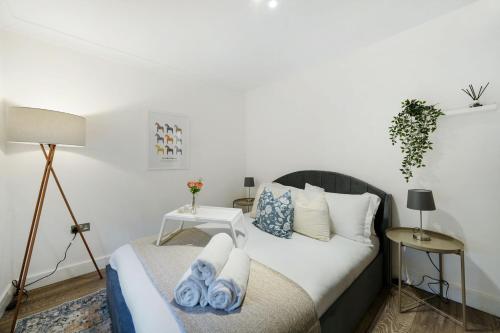 a bedroom with a bed with towels on it at Livestay Affordable Studio/1Bed Apartments in E14 in London