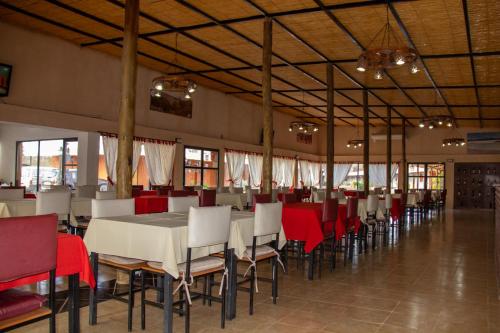 a dining room with white tables and chairs and red chairs at Don Remo in Villa Unión