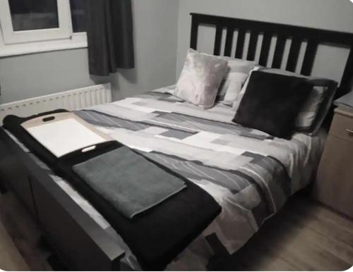 a bed with a black and white blanket and pillows at Daves guest room with use of local gym in Featherstone