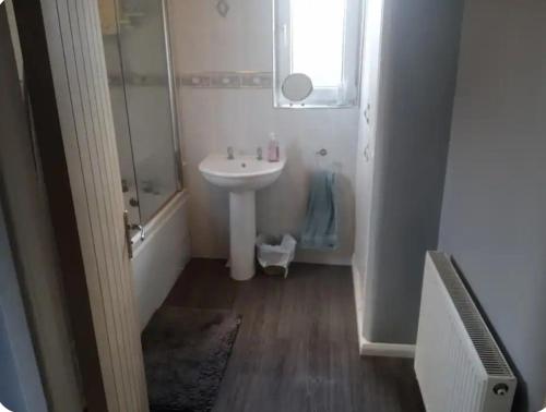 y baño blanco con lavabo y ducha. en Daves guest room with use of local gym, en Featherstone
