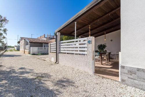 ein Gebäude mit einem weißen Zaun neben einem Haus in der Unterkunft Edoné, Wohnung mit Blick auf einen Sandstrand in Santa Maria Del Focallo