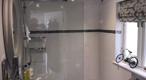 a bathroom with a shower and a bike on the wall at Luxury home on Whitsand Bay in Cawsand