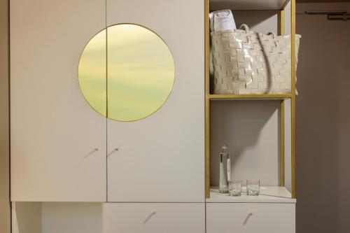 a bathroom with a mirror and a white cabinet at Hotel Nettuno in Bardolino