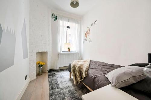 Dormitorio blanco con cama y chimenea en The Perfect Retreat-3 bedroom garden with Hot Tub en Londres