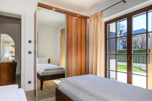 - une chambre avec un lit et une grande fenêtre dans l'établissement Olympia-Residence, à Garmisch-Partenkirchen