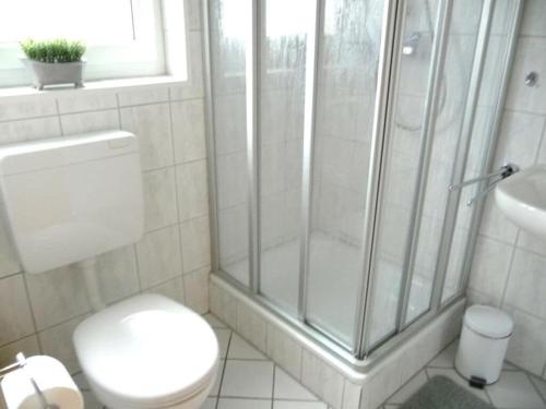 uma casa de banho com um chuveiro, um WC e um lavatório. em "Friesenhörn" 31 Merchant em Horumersiel