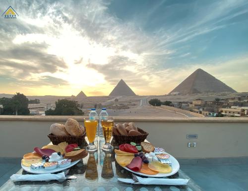 a table with food and drinks and the pyramids at Egypt Pyramids Inn in Cairo