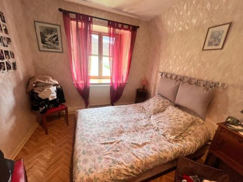 Schlafzimmer mit einem Bett und einem Fenster in der Unterkunft La Grange de Marcel in Retournac