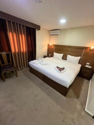 a hotel room with a large bed and a chair at Petra Aretas Hotel in Wadi Musa