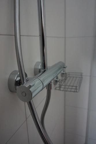 a shower head with a hose in a bathroom at Natur & Ruhe, neu & zentral, im Herzen von Freudenstadt in Freudenstadt