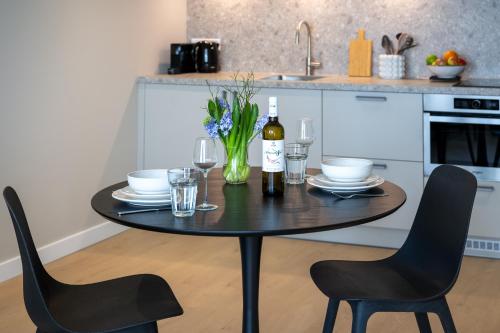 a black table with two chairs and a bottle of wine at Hotel Royal in Noordwijk