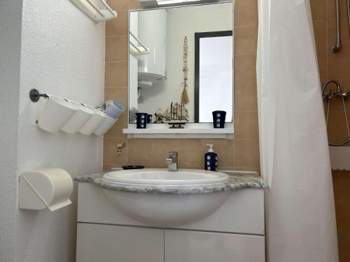 een badkamer met een wastafel en een spiegel bij Appartement Fleury-Saint-Pierre-la-Mer, 3 pièces, 5 personnes - FR-1-229D-268 in Fleury