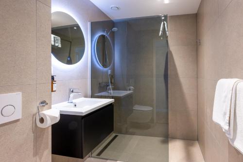 a bathroom with a sink and a shower at Hotel Royal in Noordwijk