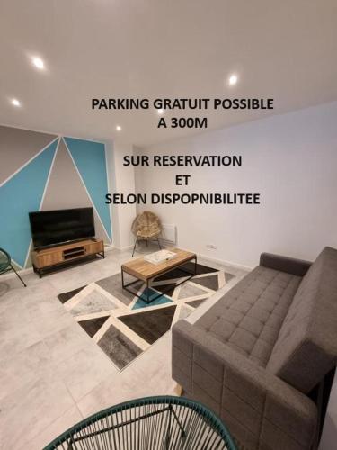 een woonkamer met een bank en een televisie bij VALSCOSY parking - Activités illégales interdite in Valenciennes