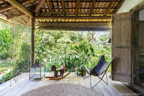 a living room with a wooden floor and chairs and trees at Casas da Lia in Trancoso