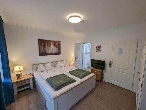a bedroom with a bed and a flat screen tv at Haus Am Waldesrand in Herzberg am Harz
