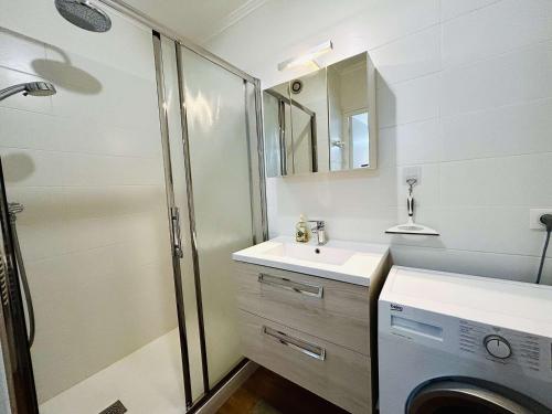 une salle de bain avec un lavabo et une machine à laver dans l'établissement Appartement rénové face mer avec terrasse, box privatif, 2 pièces, 4 couchages - Pornichet - FR-1-245-132, à Pornichet