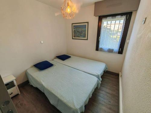 une petite chambre avec deux lits et une fenêtre dans l'établissement T2 RENOVE, CLIM, WI-FI, PISCINE, TENNIS, PARKING PRIVÉ À 100M PLAGE ROQUILLE - FR-1-607-20, au Cap d'Agde