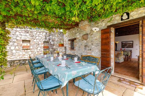 een tafel met blauwe stoelen en een stenen muur bij Villa Formaga - relax and view lake - Happy Rentals in Gargnano
