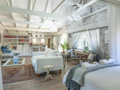 uma sala de estar com 2 camas e uma cozinha em Rose and Ivy Cottages em Louis Trichardt