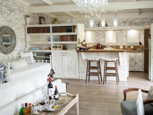 Rose and Ivy Cottages في لويس تريشارد: غرفة معيشة مع أريكة بيضاء ومطبخ