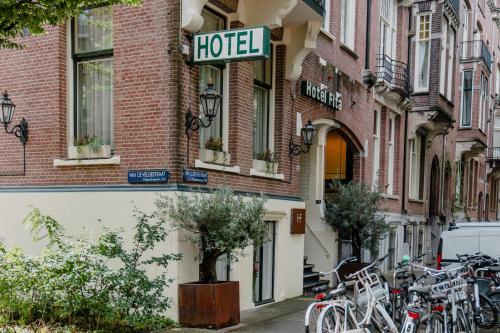 uma fila de bicicletas estacionadas em frente a um hotel numa rua em Hotel Fita em Amsterdã
