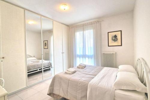 バルドリーノにあるAppartamento Li.da.feの白いベッドルーム(ベッド1台、鏡付)