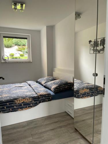 1 dormitorio con 2 camas y ventana en Apartament Łąkowa z tarasem en Brodnica