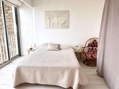 une chambre blanche avec un lit et une fenêtre dans l'établissement Appartement avec Vue Mer, Climatisation et Cuisine Équipée - Le Lavandou - FR-1-308-158, au Lavandou