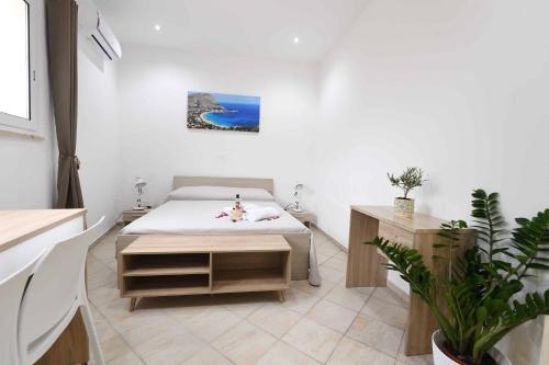 Habitación con cama y mesa. en TerrasiniPalermoVacation Rentals, en Terrasini