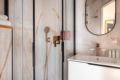 La salle de bains est pourvue d'un lavabo et d'un miroir. dans l'établissement Hôtel Des Marronniers, à Paris