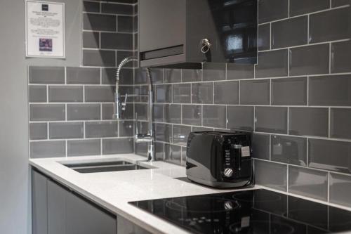 eine Küche mit einer Spüle und einem Toaster auf der Theke in der Unterkunft Cosy and Comfy City Apartment in Norwich