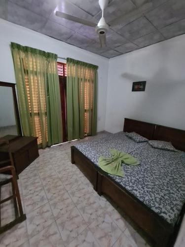 a bedroom with a bed and a chair and windows at Hotel Mihira Village in Ambanpola