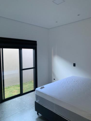 a bedroom with a bed and a large window at Casa de Campo Resort em Pardinho (Piscina c/ Borda Infinita) in Pardinho