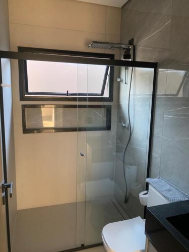 a bathroom with a shower and a toilet and a window at Casa de Campo Resort em Pardinho (Piscina c/ Borda Infinita) in Pardinho