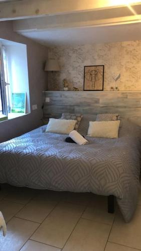 um quarto com uma cama grande e 2 almofadas em La Tour charmant studio très bien situé em Tours-en-Savoie
