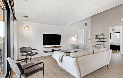 a living room with a couch and a tv at Cozy Home In Millinge With Sauna in Millinge