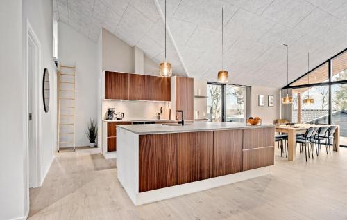 an open kitchen and dining room with wood cabinets at Cozy Home In Millinge With Sauna in Millinge