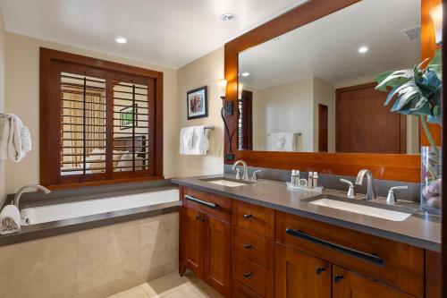 a bathroom with two sinks and a large mirror at Ko Olina Beach Villas B610 in Kapolei