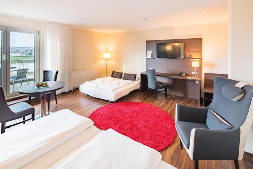 Airways Hotels Frankfurt Airport West في رونهيم: غرفة معيشة مع سرير وطاولة وكراسي