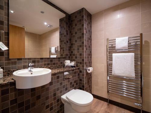 bagno con lavandino, servizi igienici e specchio di Old Loans Inn a Troon