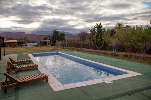 uma piscina com dois bancos ao lado em Don Remo em Villa Unión